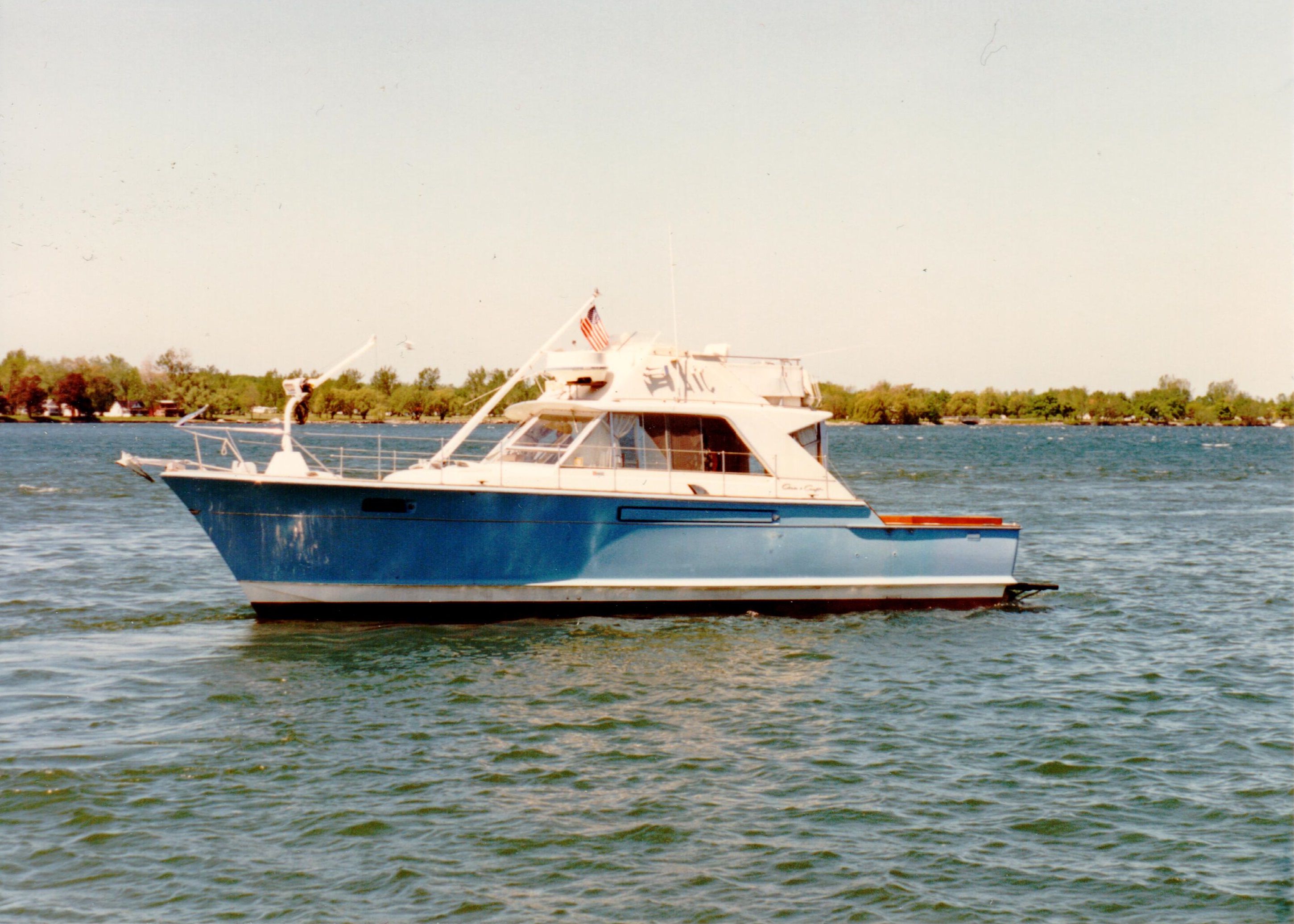 A photo of a blue and white boat facing left in the water.