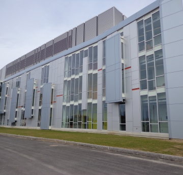 a three-story grey academic building with many windows