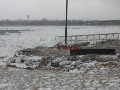 Several feet of ice piled up on edge of the water.