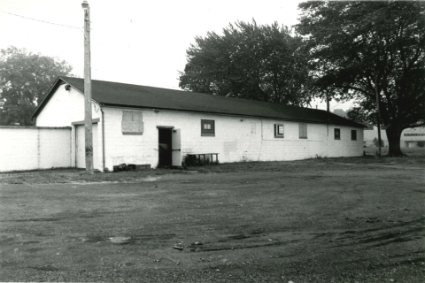 black and white photo of a one story long rectangular building with a low roof