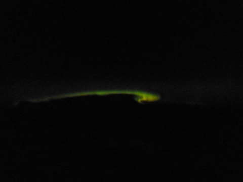 A dark sky with a swirl of green across the middle.