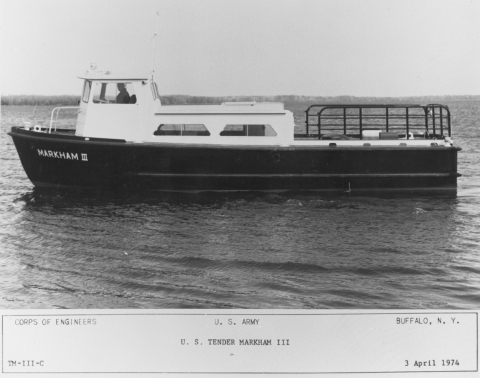 Black and white picture of a boat with a two-level cabin and a railing around the back deck