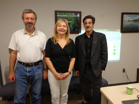 Three people pose for a picture in an office