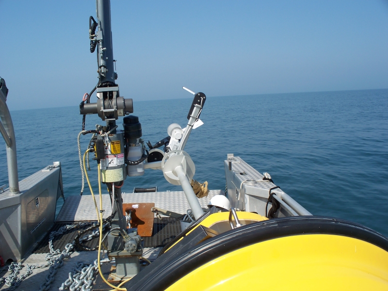 A buoy and an anchor lie on the deck of a landing craft boat on a calm day