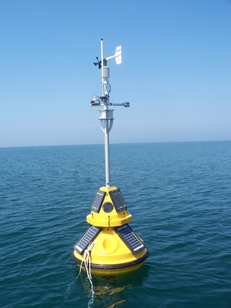 A fiberglass buoy with meteorological instruments and solar panels sitting in the water