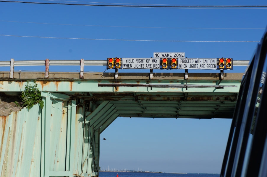 A bridge with signals and signs saying "no wake zone" and explaining how to proceed