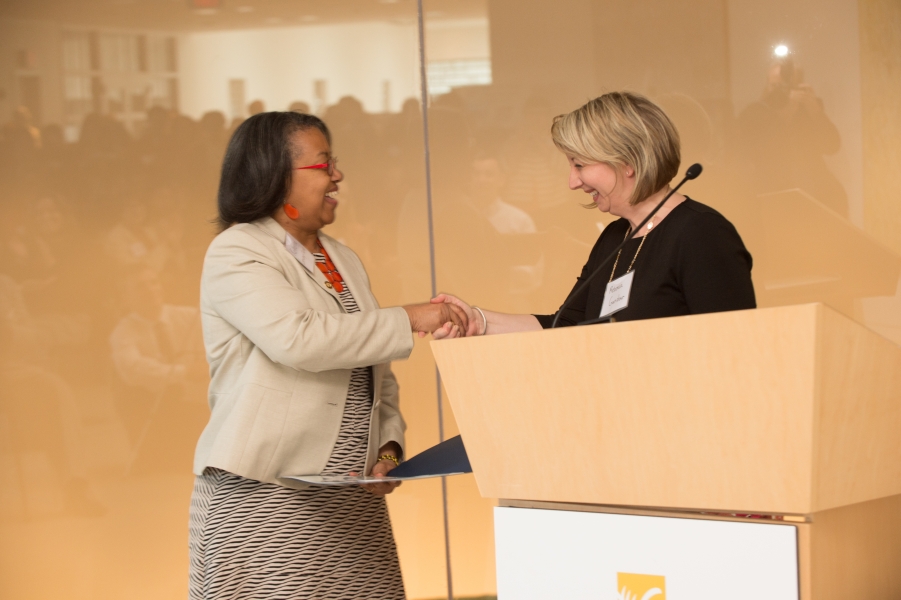 two people shake hands at a podium