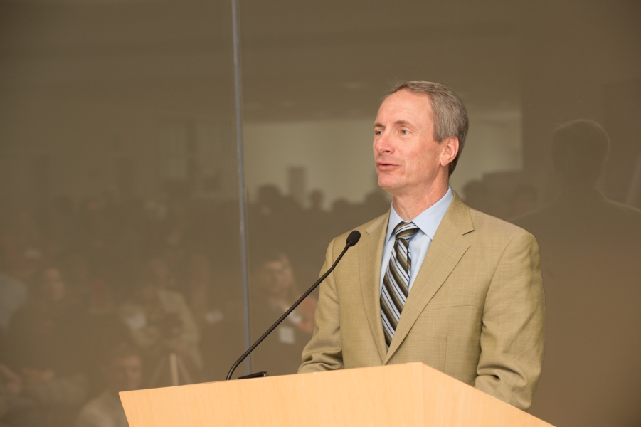 a person in a tan suit talking at a podium