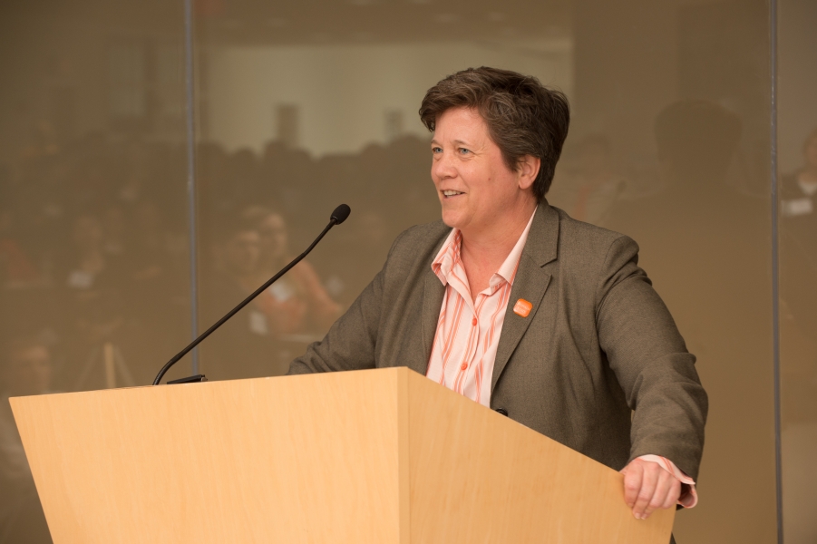 a person talking at a podium grips the side of the podium