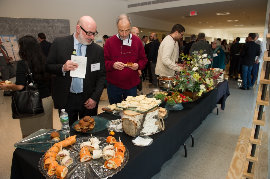 "Thomas Hahn" and "Howard Lasker" getting food from a buffet table. More people are in the background.