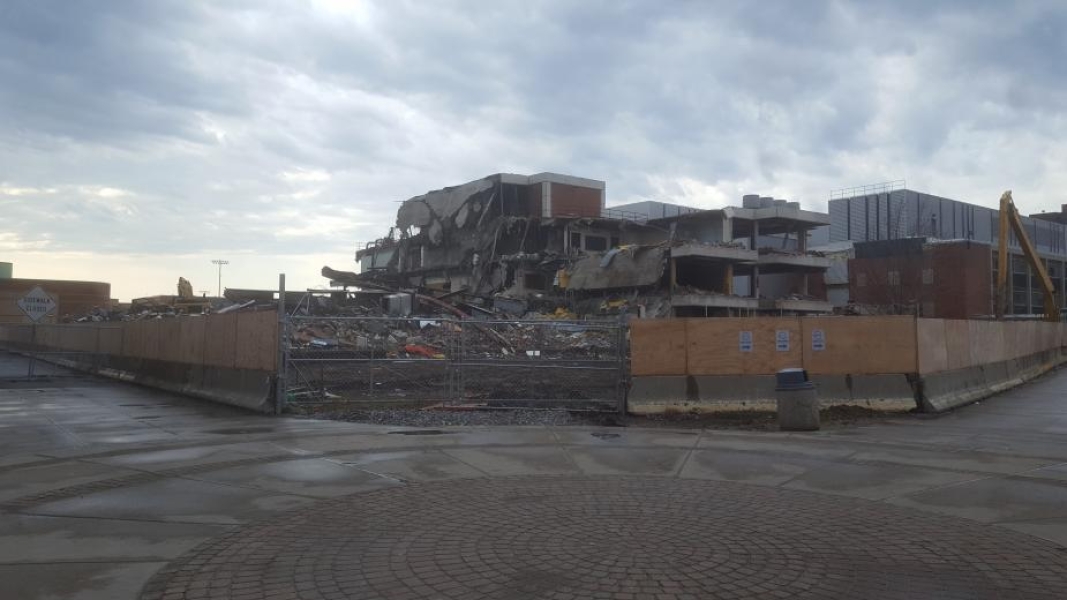 A construction site with a partially demolished building. The roof droops over the lower levels.