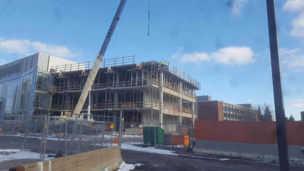 A three level concrete building under construction.