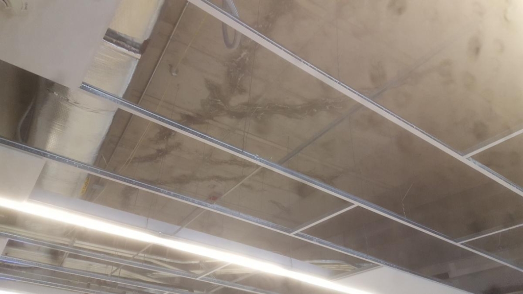 A concrete ceiling with cracks or staining.