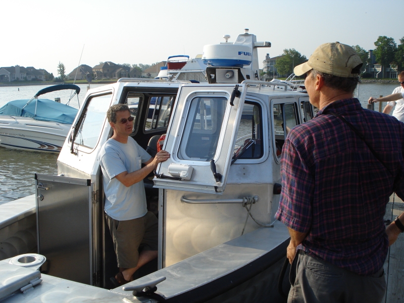 A person on a boat talks to someone on the dock