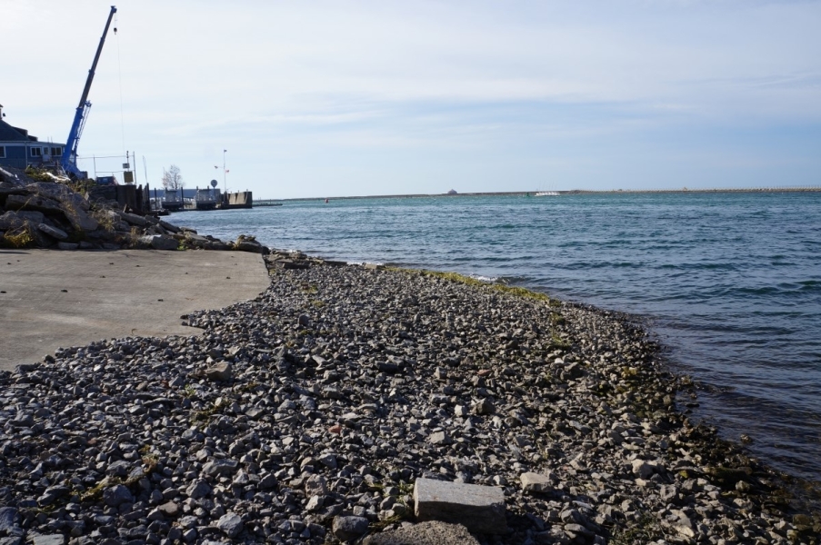 A stretch of gravel leading down to the water. There is a concrete pad further up the slope from the gravel