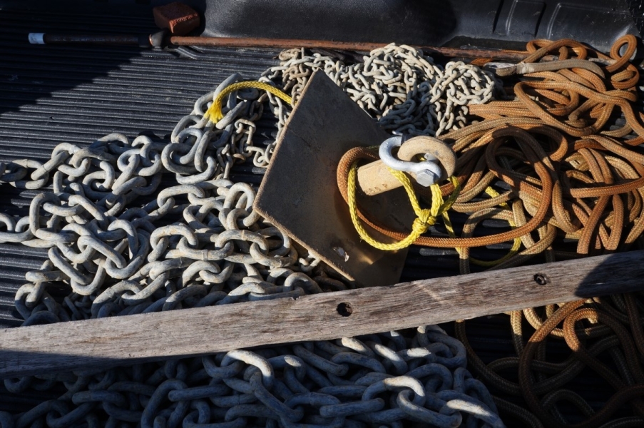 A pyramid anchor, heavy chain, and rope sit on the bed of a truck.