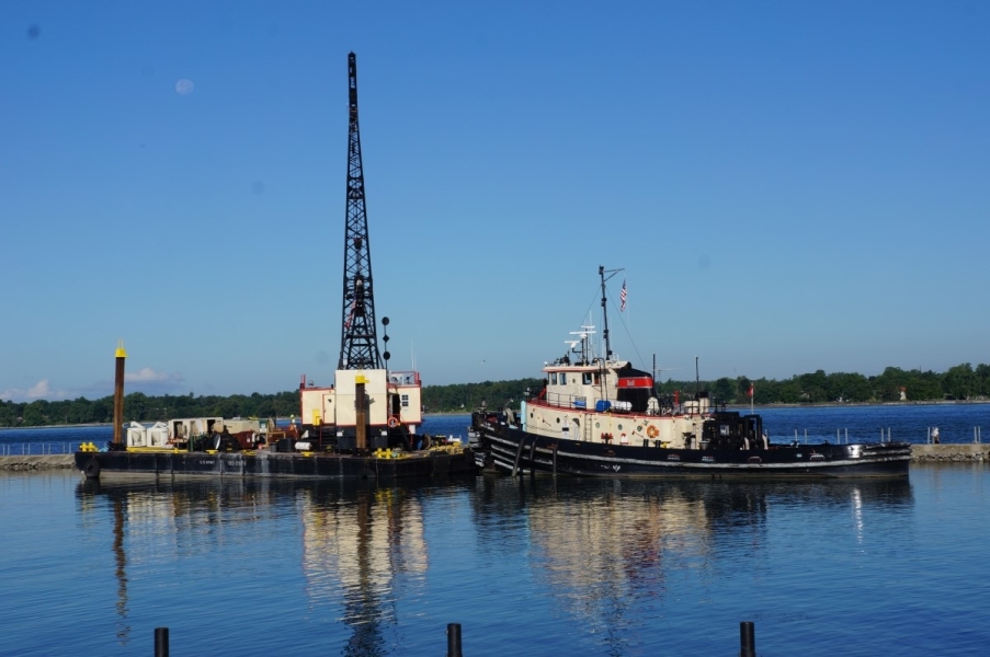 A tug and a barge with a crane in a canal