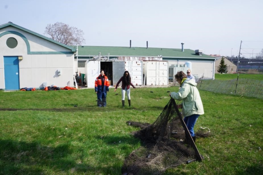 People standing in a field setting up a large net