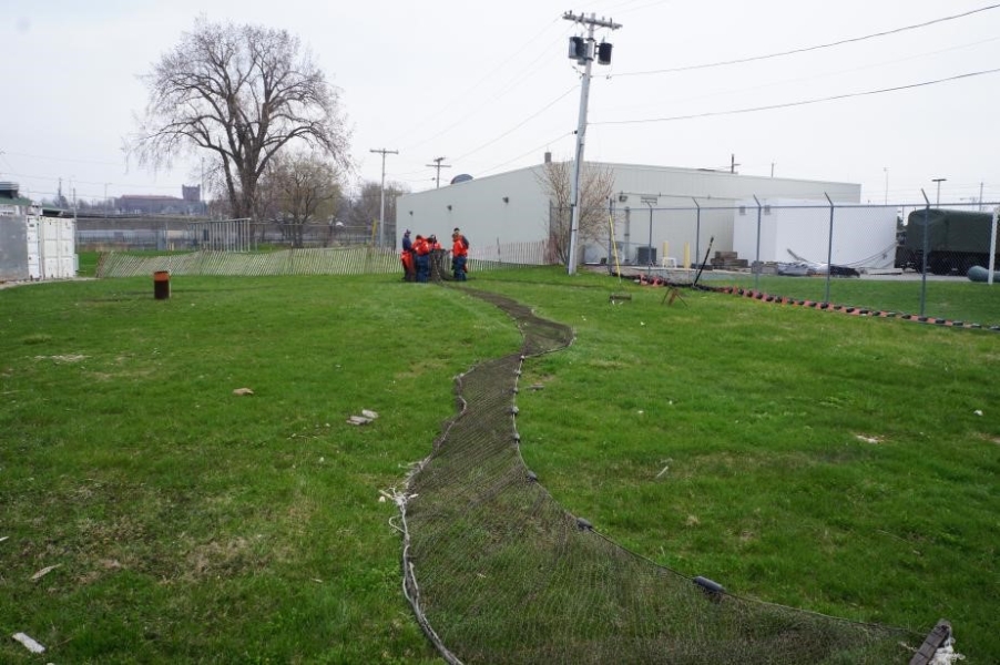 A net stretches through the grass for about 50 feet, with a group of people around the other end.