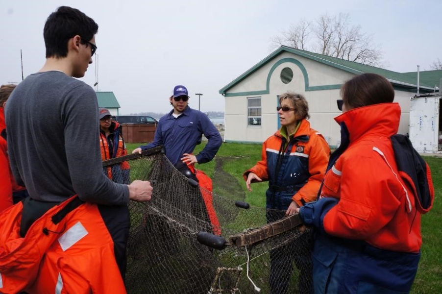 A group of people stand hold up a box-shaped net