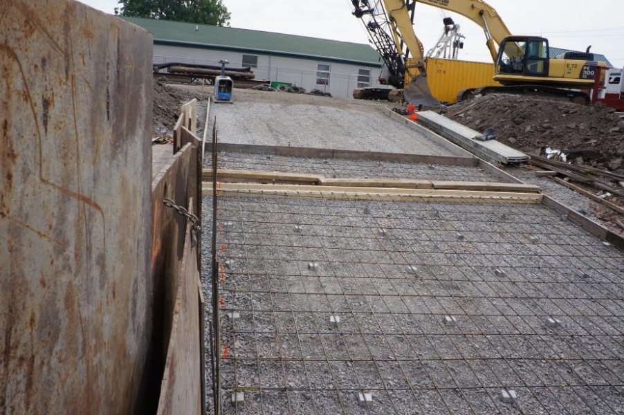 A slope at a construction site that has gravel with rebar laid on top of it.