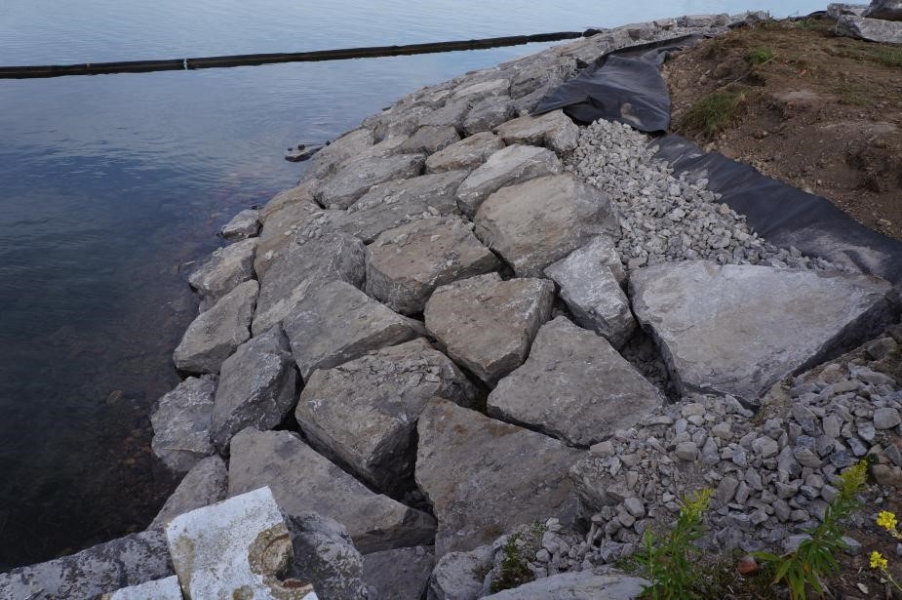 The slope down to the water is lined with evenly placed large stones.