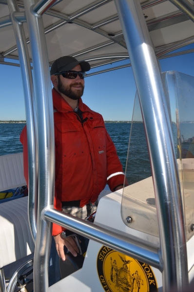 a person standing at the controls of the boat