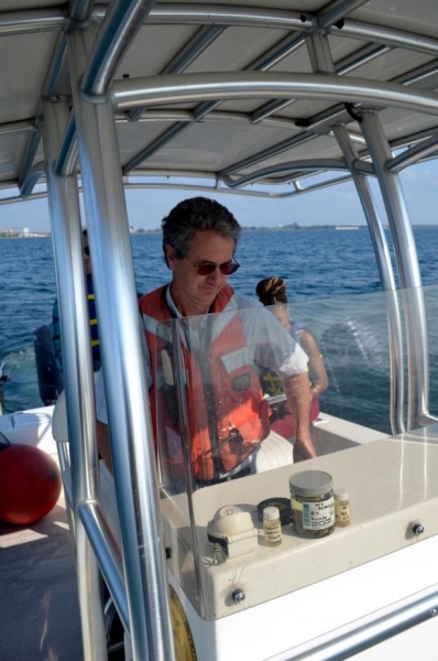 A person at the helm of a boat with a canopy