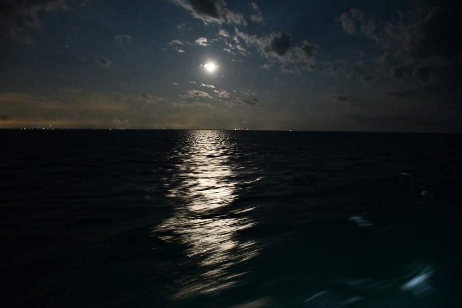 Full moon reflecting over the water at night