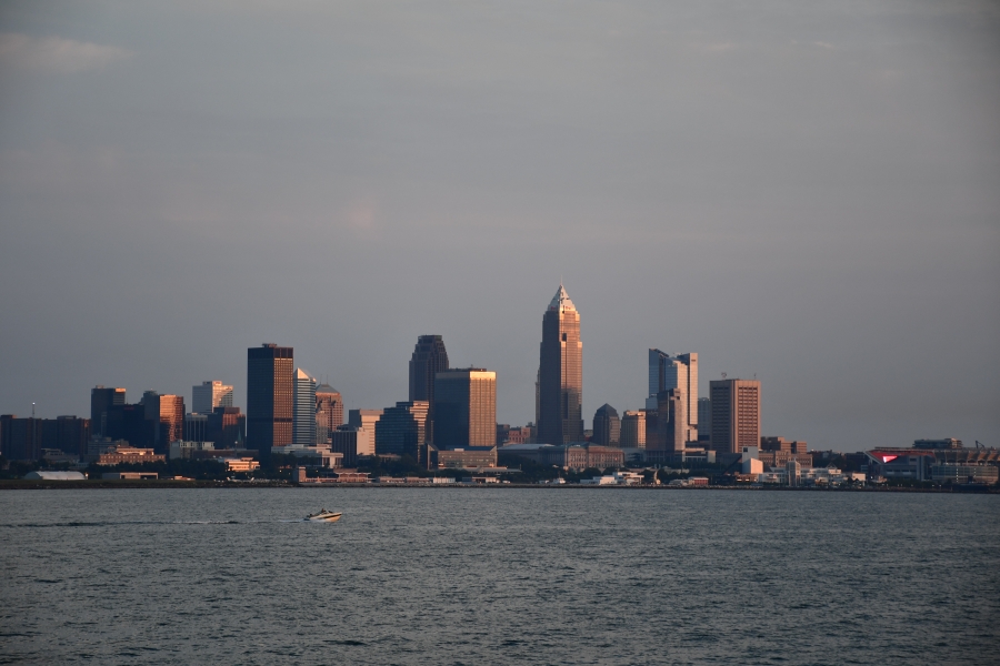 A city skyline seen from the lake, with a speedboat in the foreground