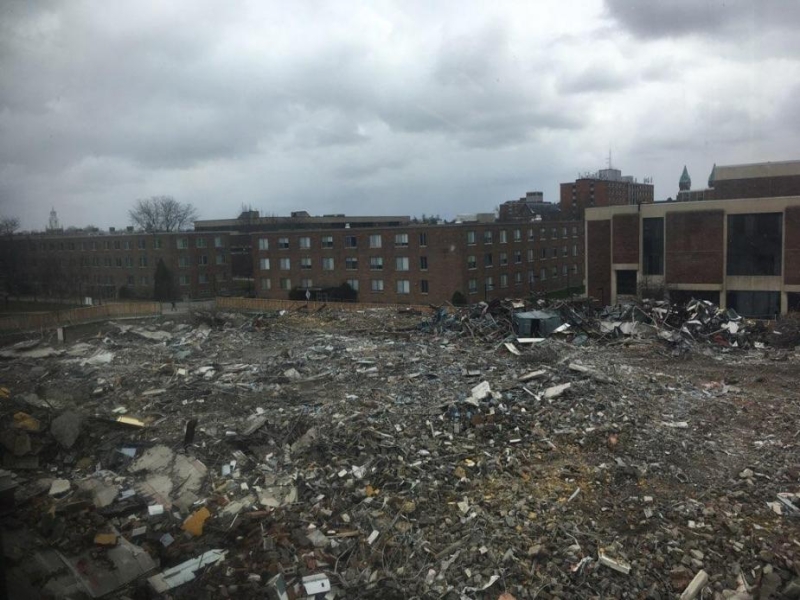 A field of rubble near some academic buildings.