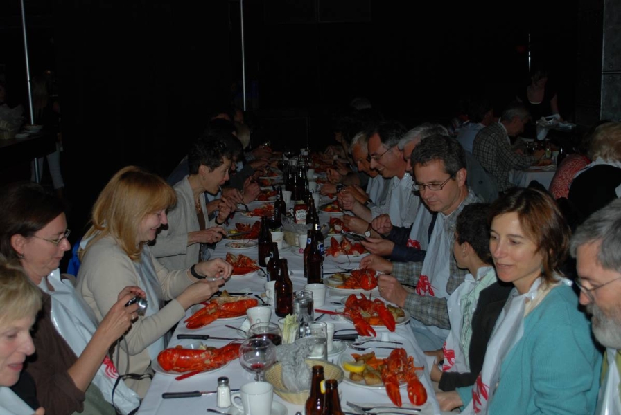 a long table of people eating lobster