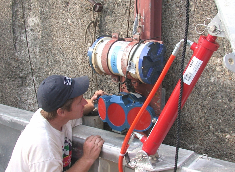 A person looks at some equipment attached to the side of a concrete wall