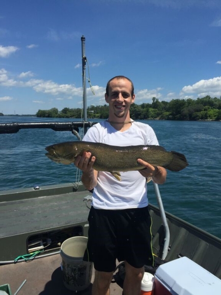 A person on a boat holding a large long fish