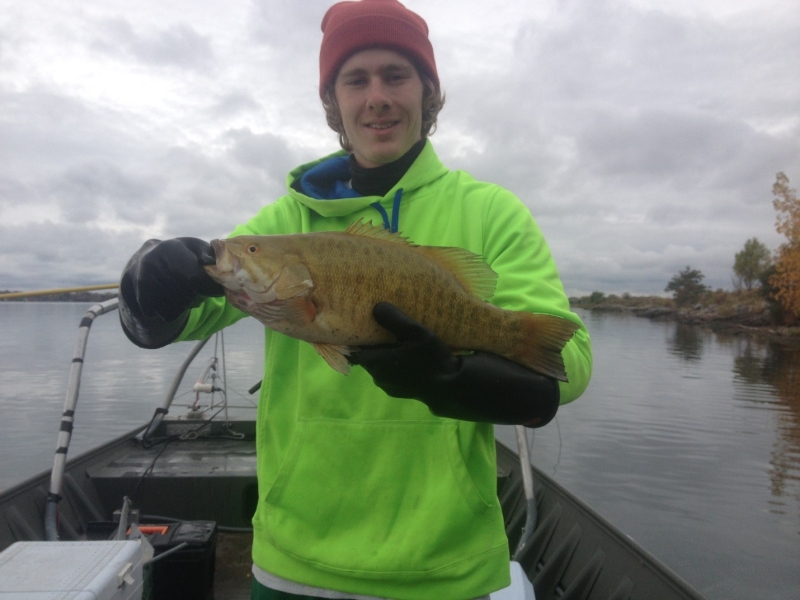 A person on a boat holding a large fish with subtle stripes