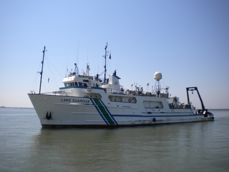 A ship called Lake Guardian sits in the water.