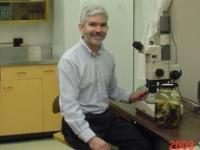 portrait of Randal Snyder sitting next to a microscope