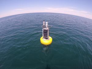 A buoy with meteorological equipment and solar panels on the open water.