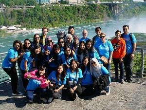 a group of people stand in front of a railing at Niagara Falls